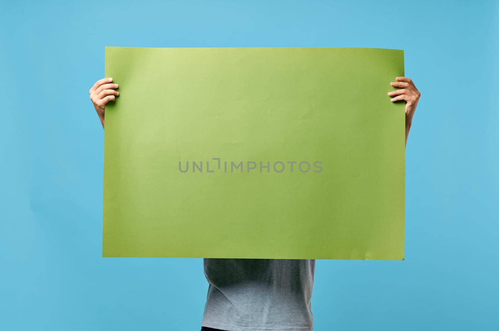 man holding green banner marketing copy space blue advertising background by SHOTPRIME