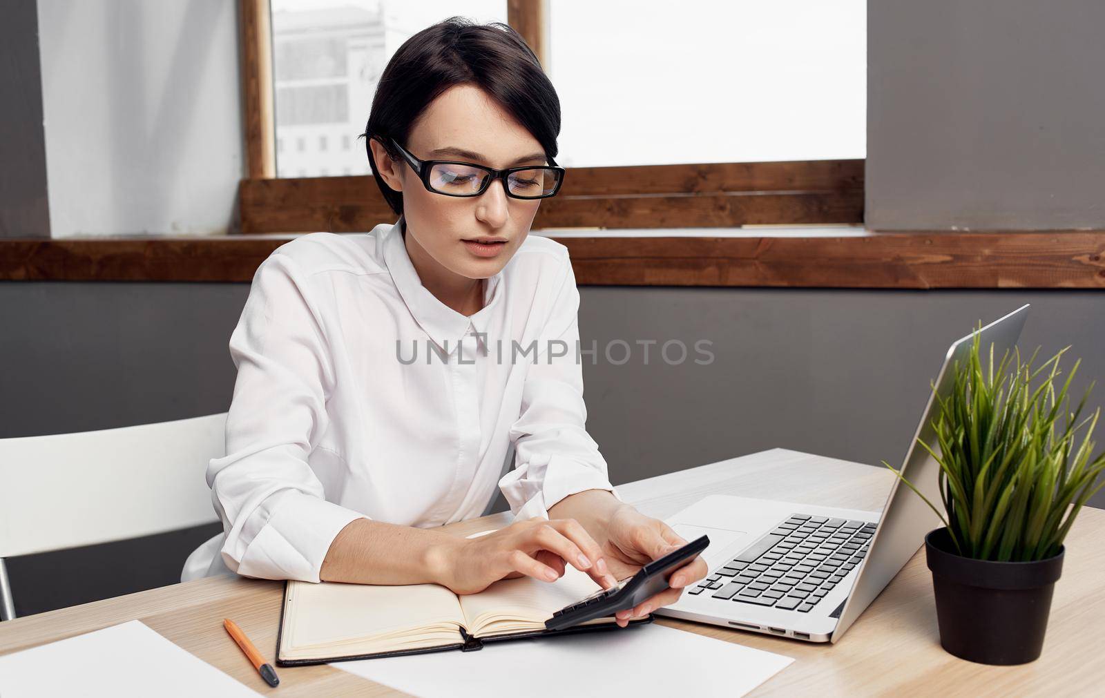 woman working behind laptop in office business finance and notepad on table by SHOTPRIME