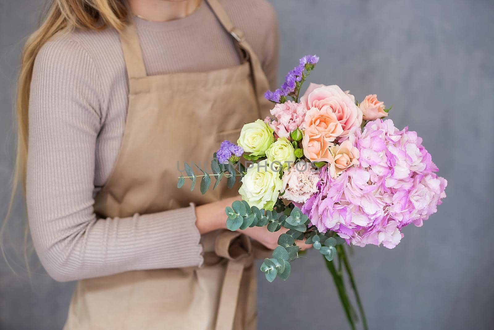 Florist at work. Female hands collect a romantic bouquet of roses. by galinasharapova