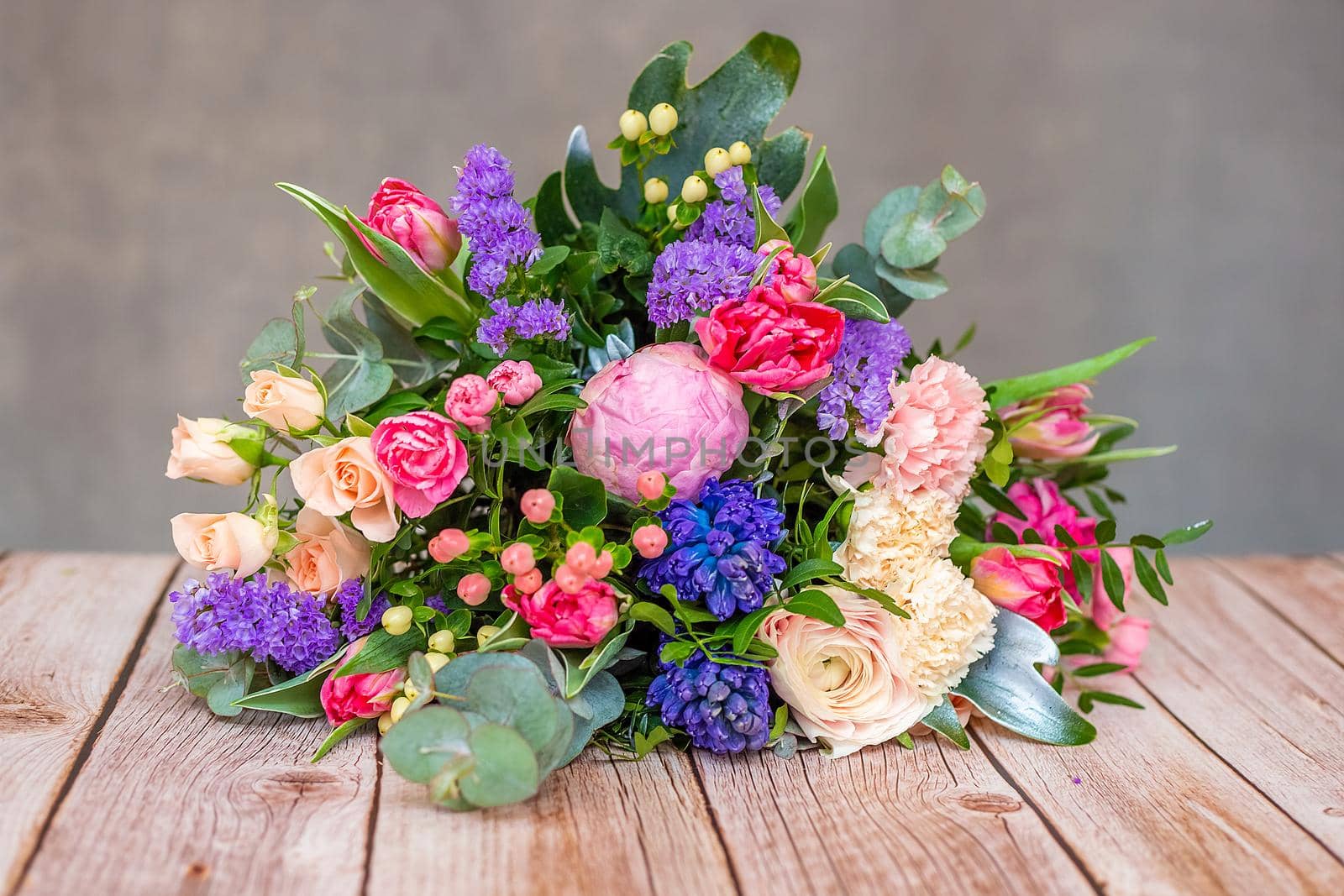 Close up view of a beautiful bouquet of mixed coloful flowers on wooden table. by galinasharapova