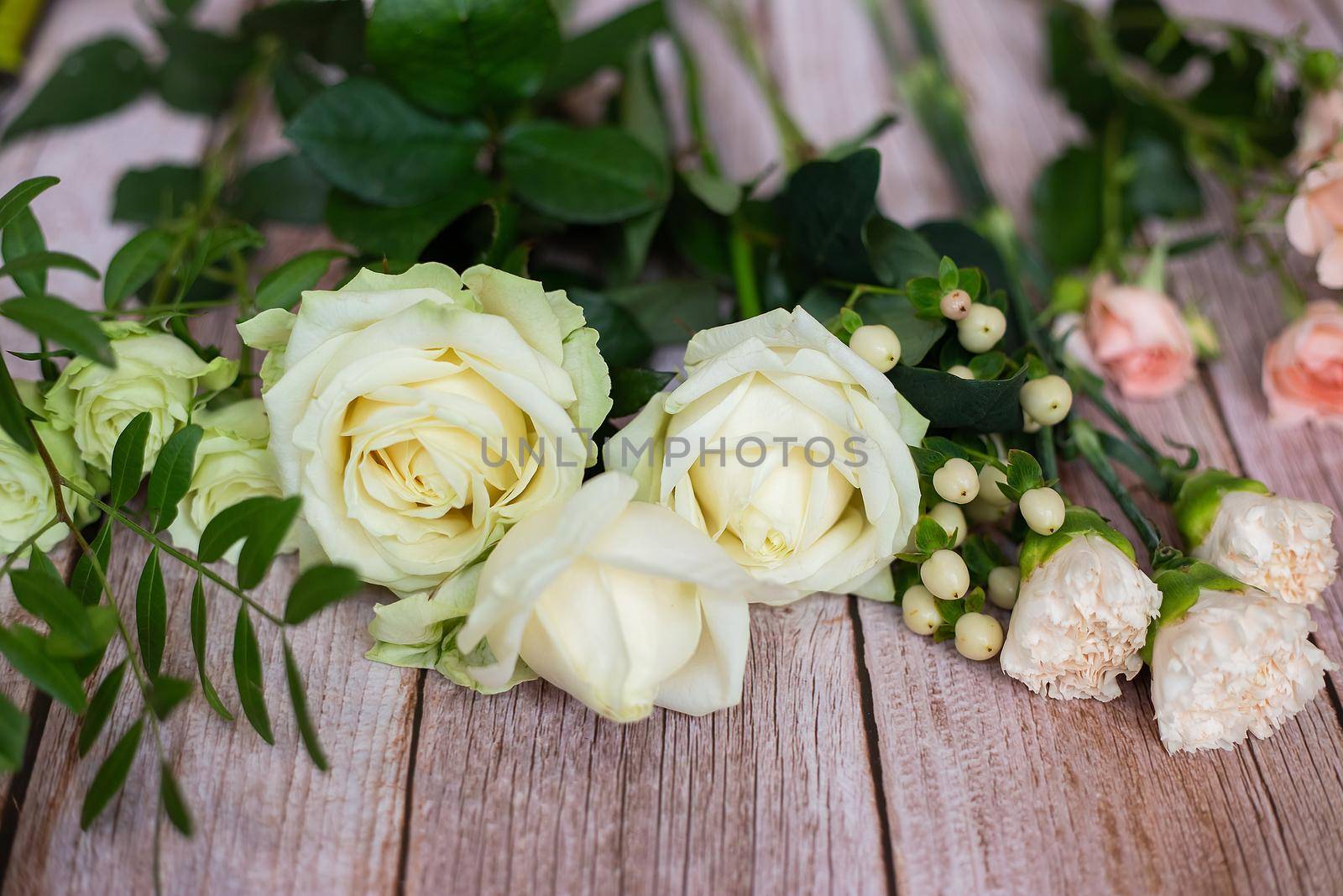 Close-up of different pastel roses in a bouquet on the table at the florist by galinasharapova