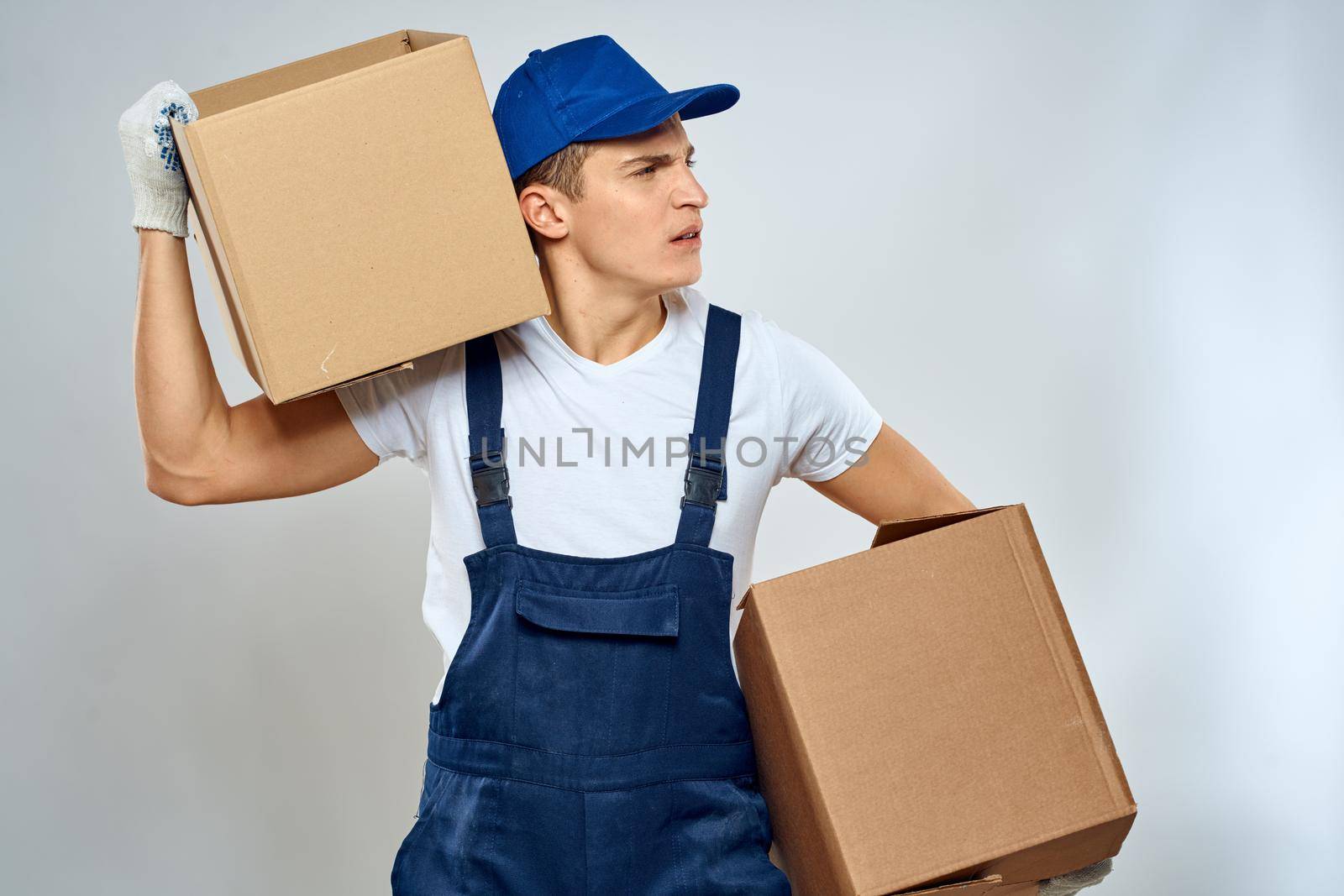 A man in a working uniform loading cardboard boxes providing services. High quality photo