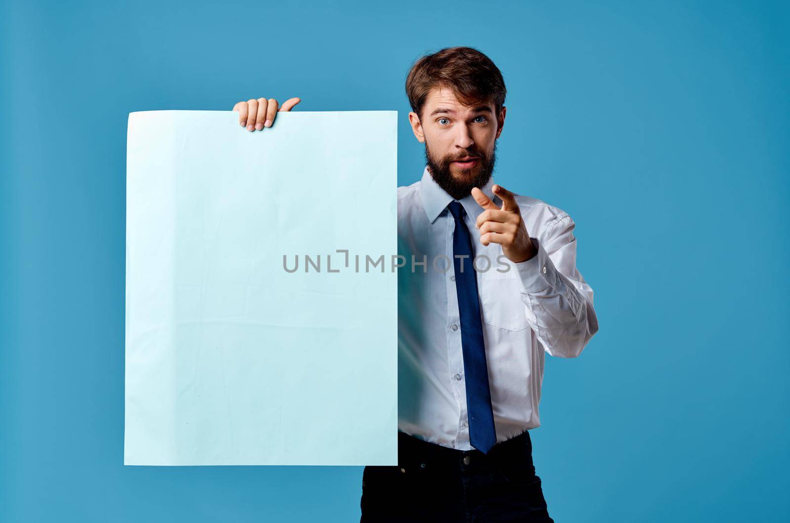 emotional man shirt with tie holding banner advertisement blue background. High quality photo