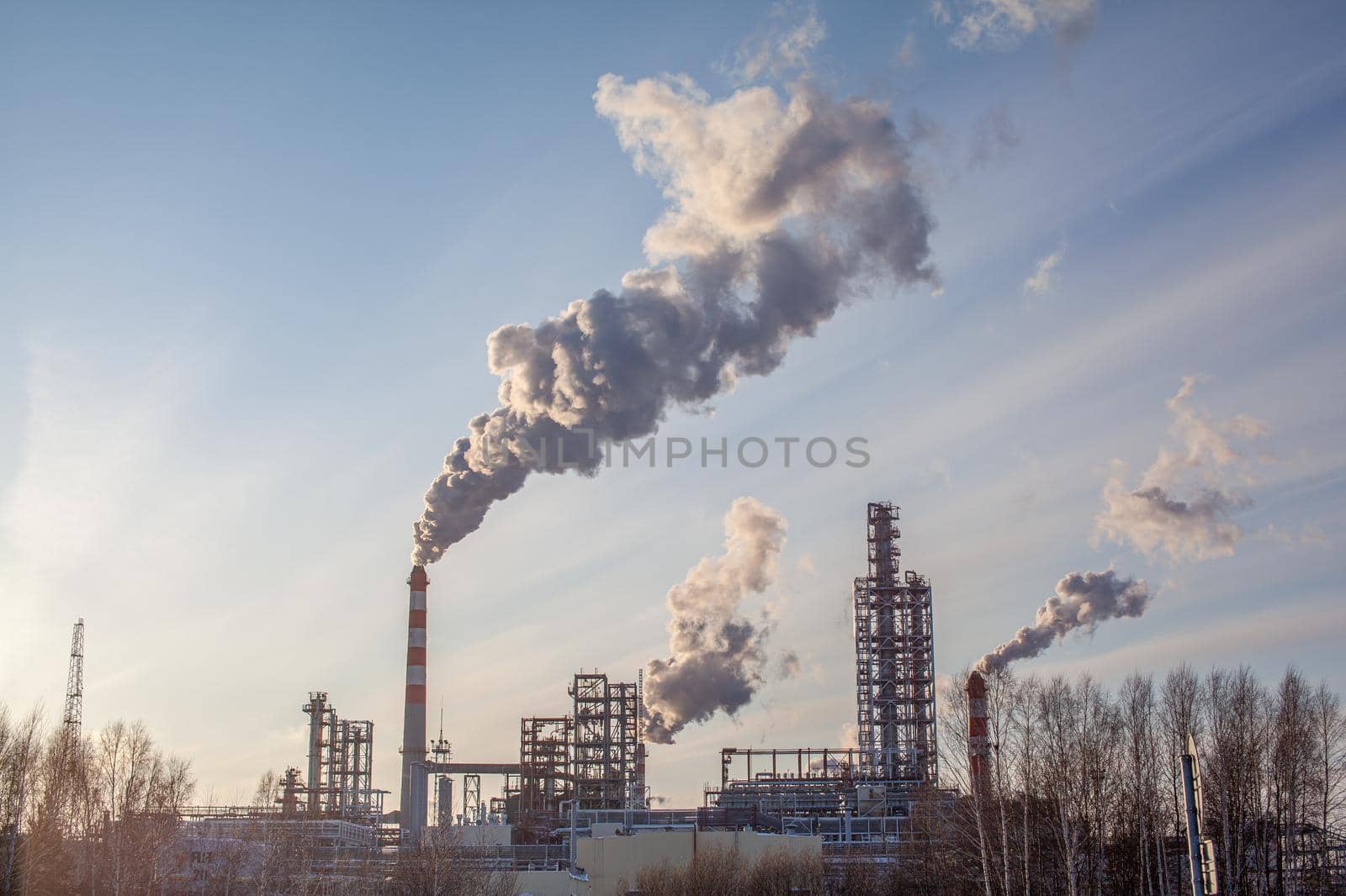 Petrochemical industrial factory of heavy industry, power refinery production with smoke pollution. Thick smoke is coming from the factory's chimney