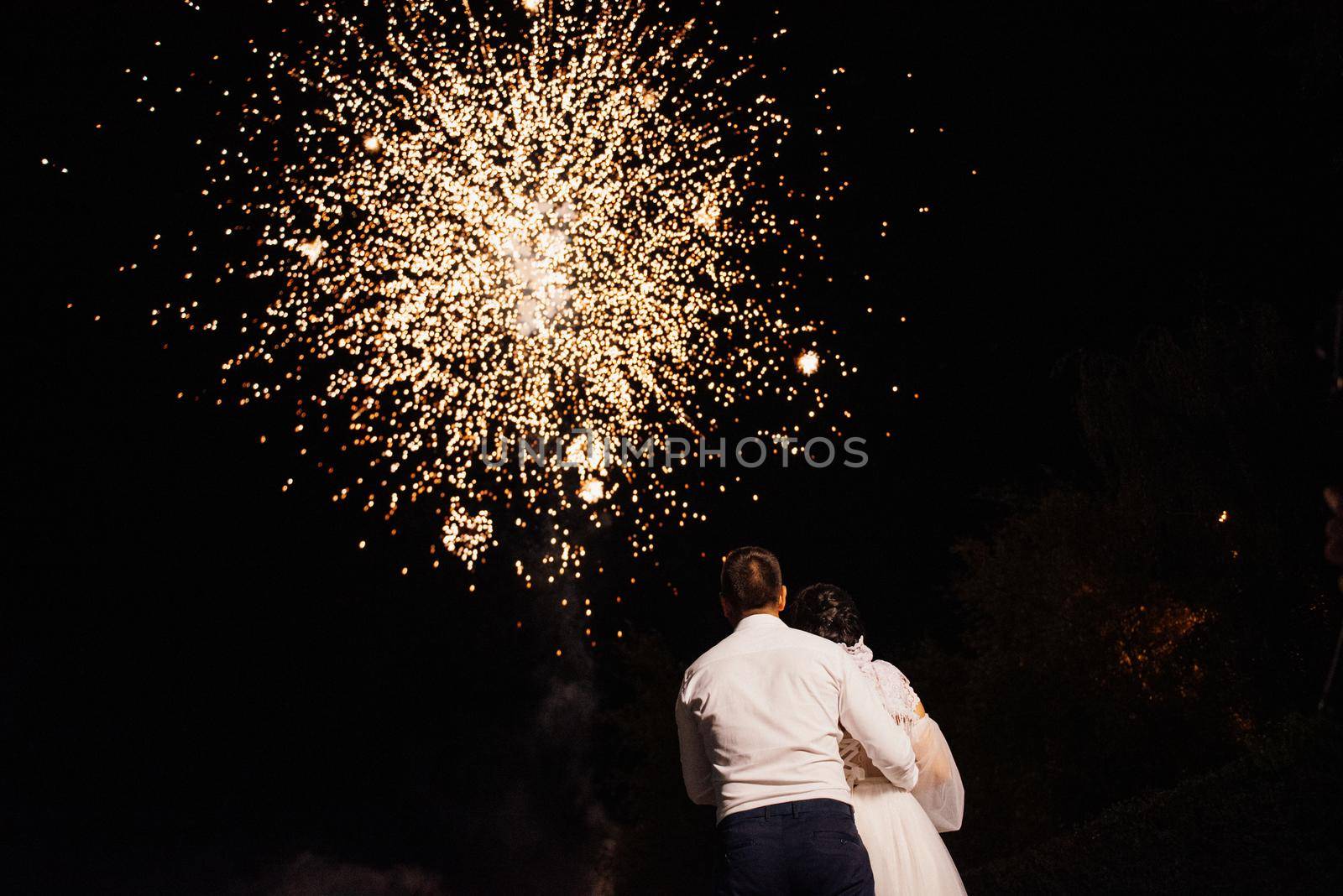 light night fire show on the background of the night sky with newlyweds