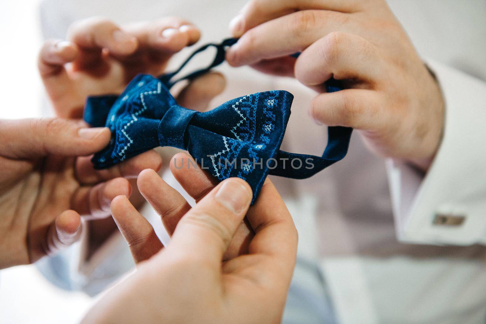 Shaffer helps groom tie blue bow tie by Andreua