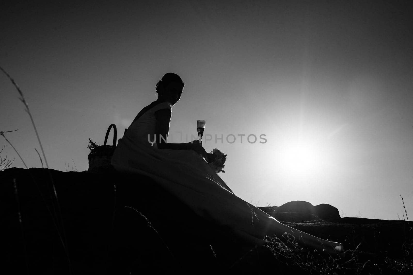 silhouettes of a happy young couple guy and girl on a background of orange sunset in the sand desert by Andreua