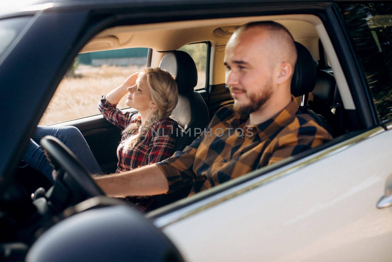 traveling by car of a young couple of a guy and a girl in plaid shirts