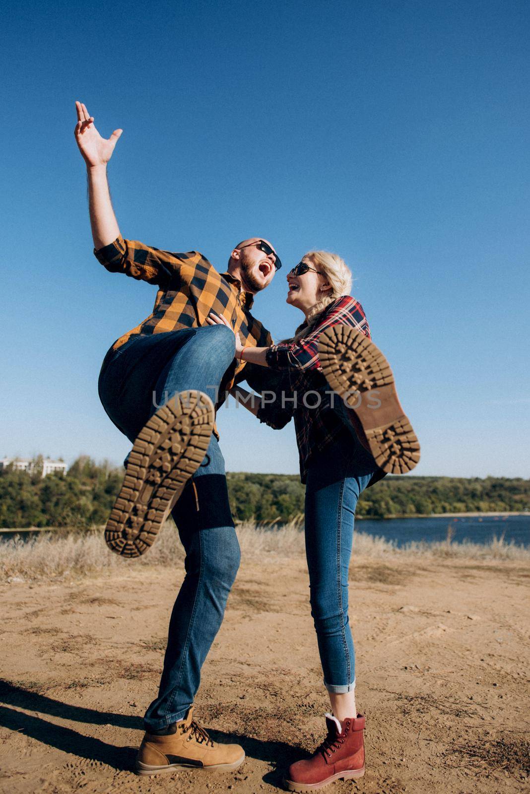 Guy and girl in caged shirts and trekking shoes on granite rocks