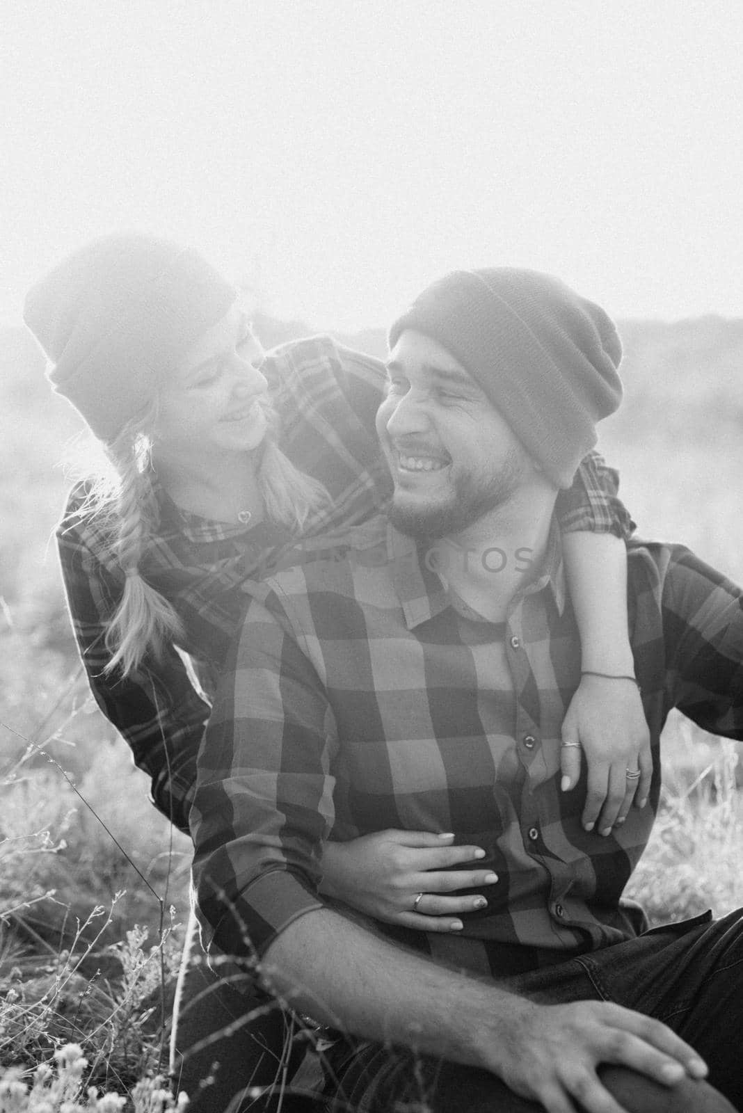 Cheerful guy and girl on a walk in bright knitted hats by Andreua