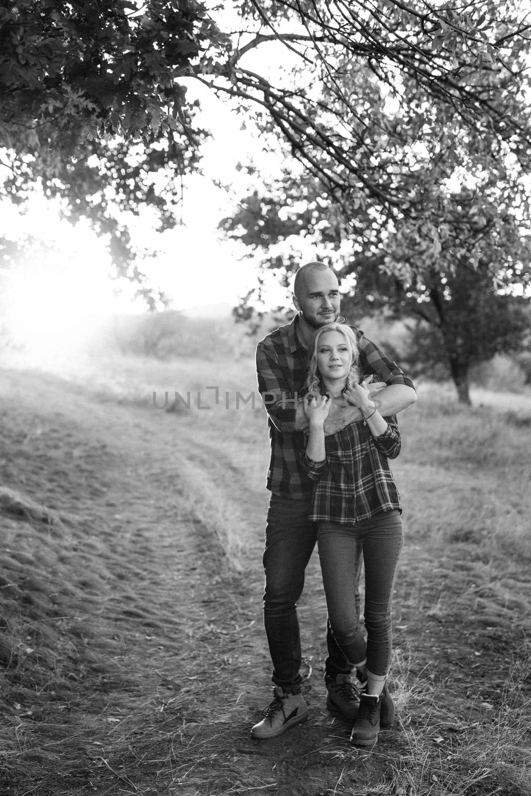 Cheerful guy with a board and a blonde girl for a walk in plaid shirts by Andreua