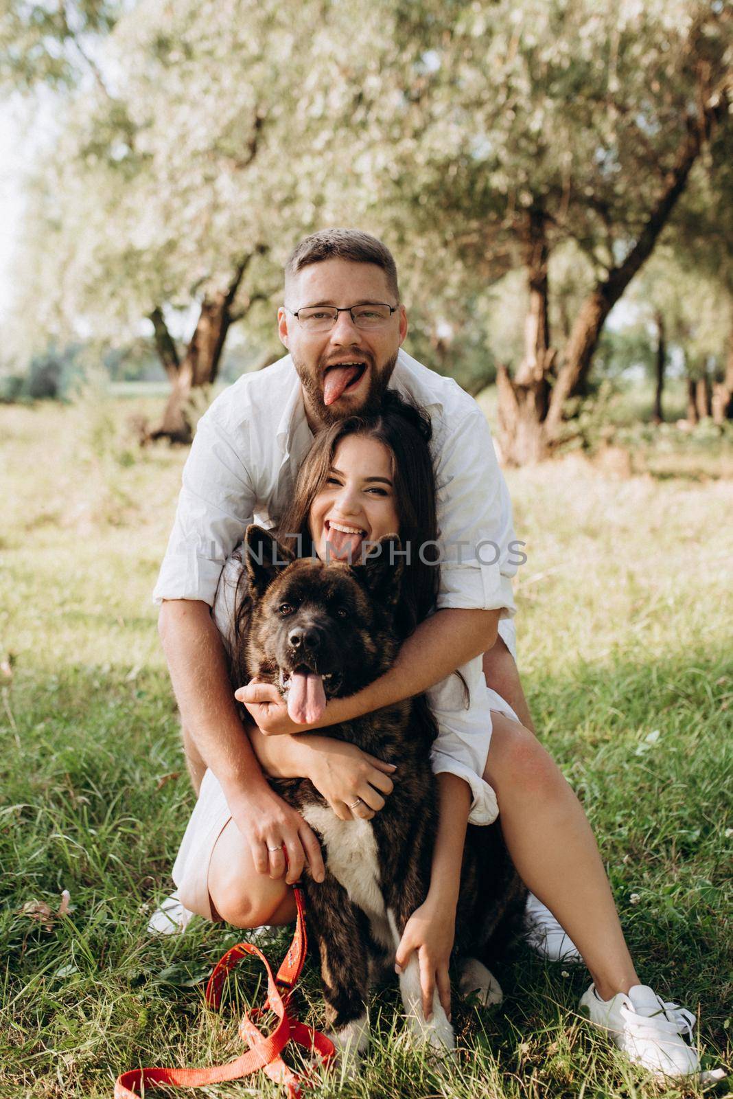 Big dog for a walk with a guy and a girl on the green prairie