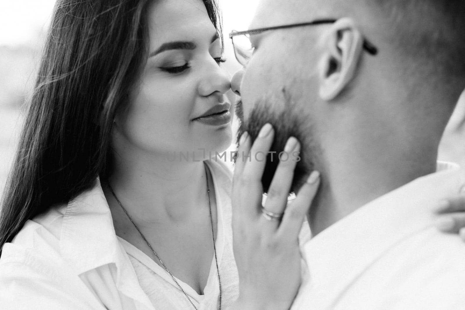 young couple in love a guy with a beard and a girl with dark hair in light clothes in the green forest