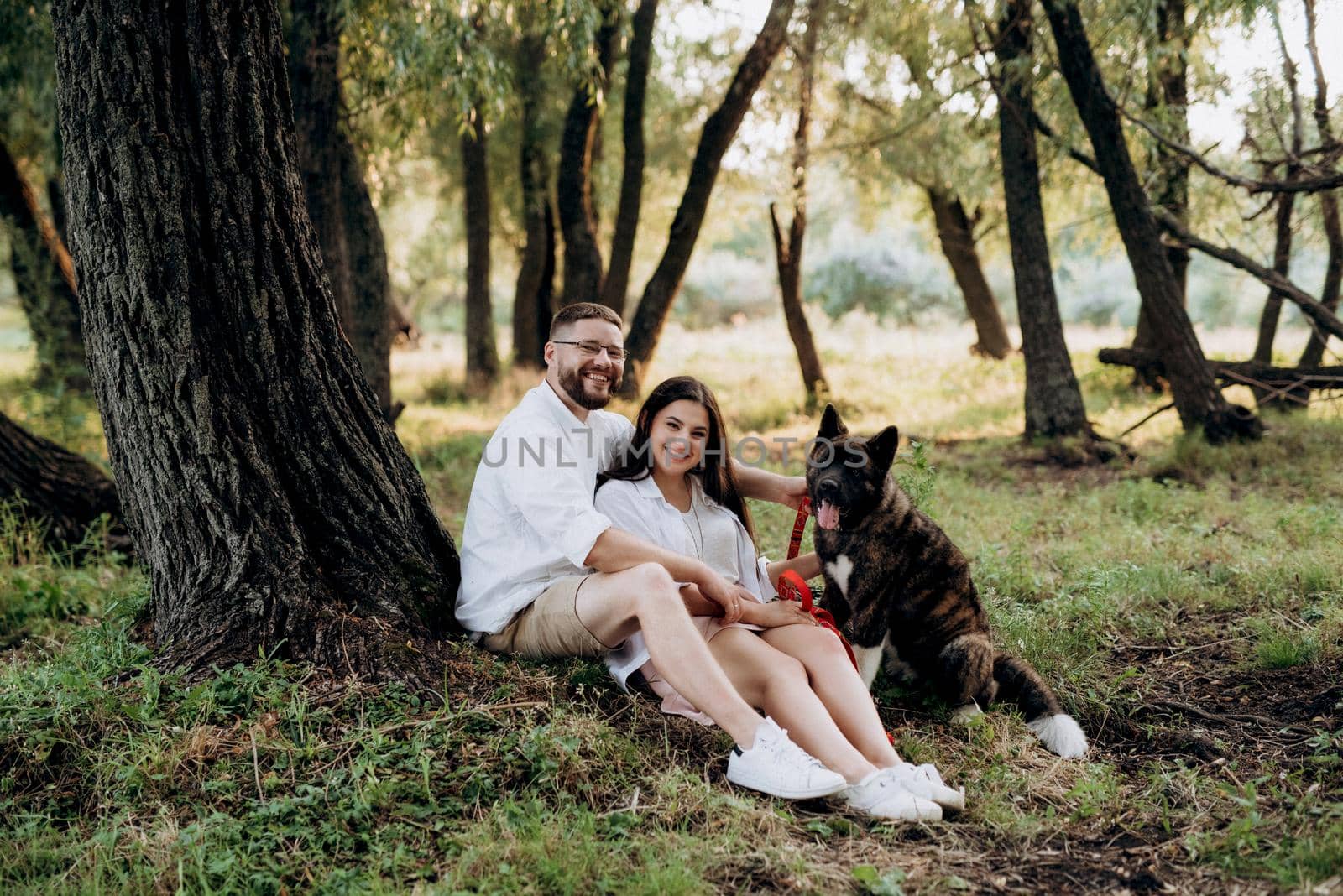 Big dog for a walk with a guy and a girl on the green prairie