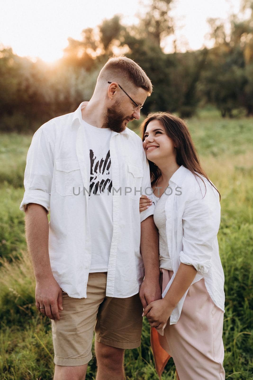 young couple in love a guy with a beard and a girl with dark hair in light clothes by Andreua