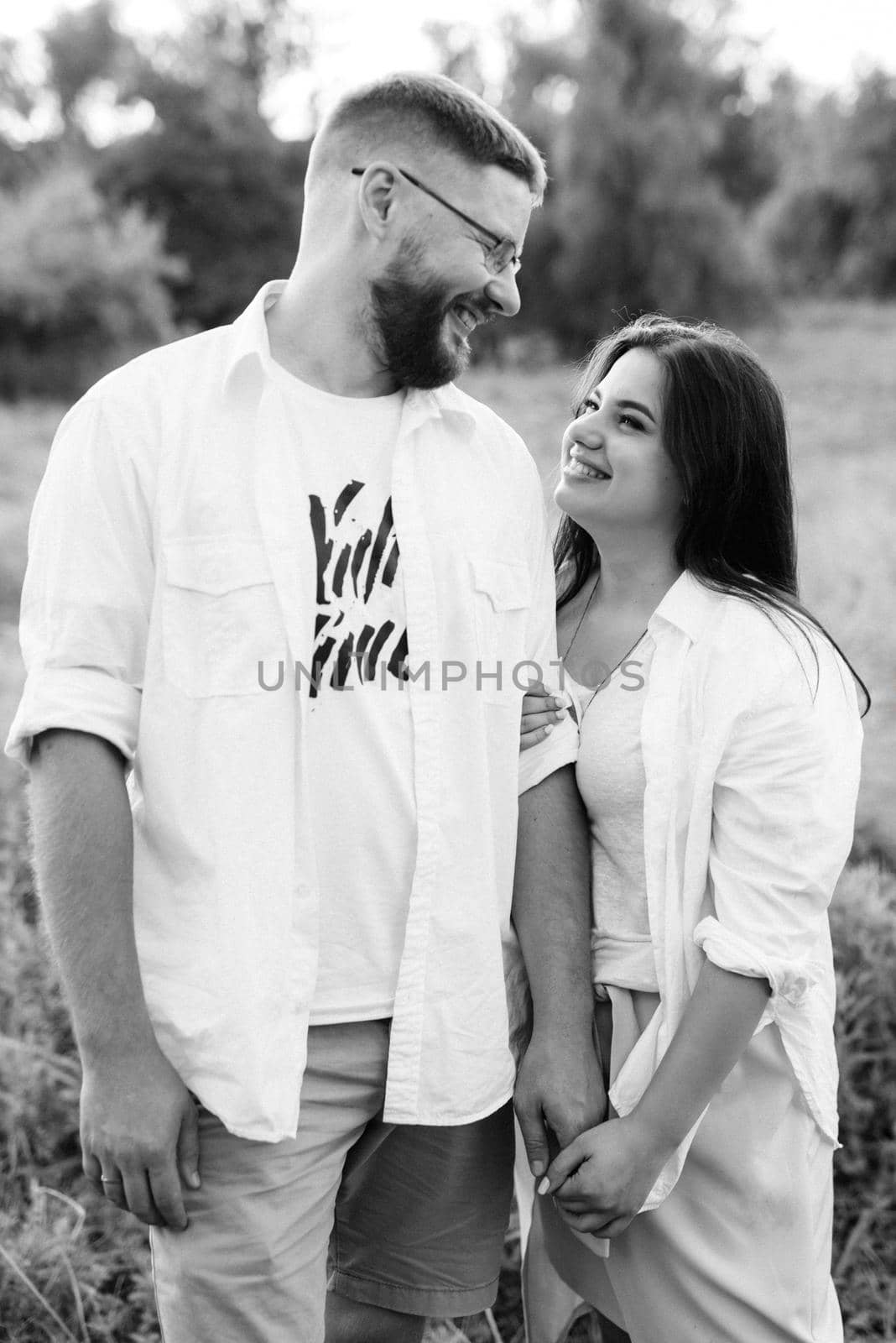 young couple in love a guy with a beard and a girl with dark hair in light clothes by Andreua