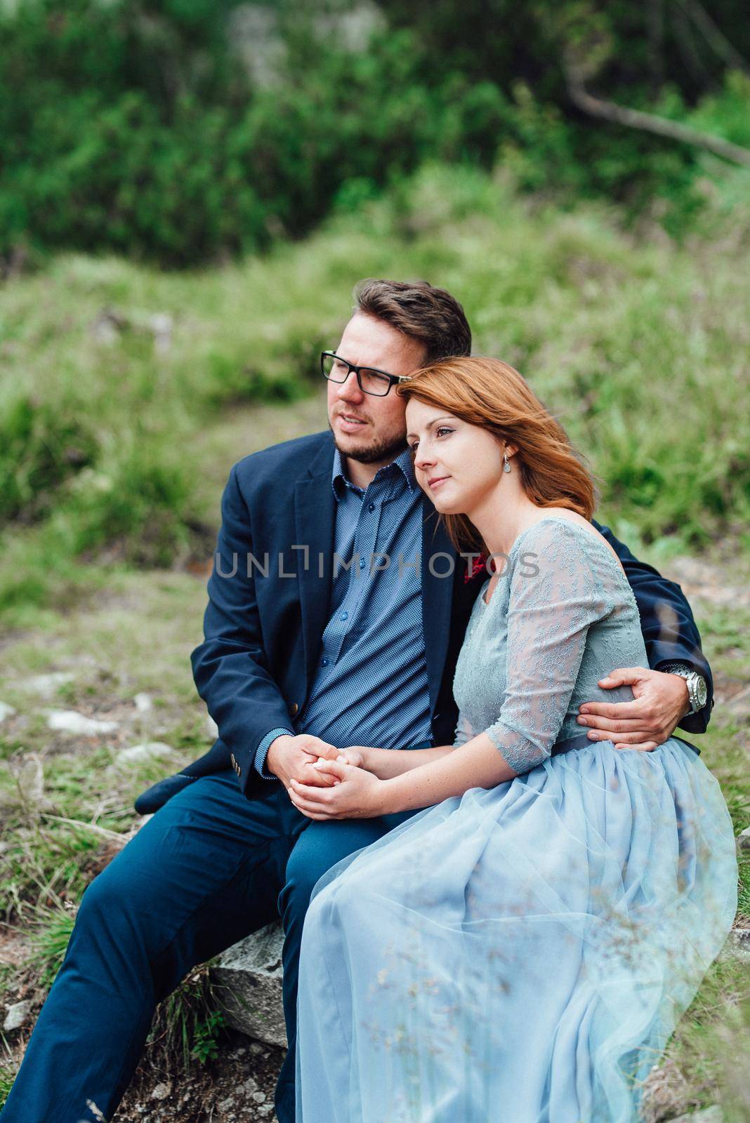 young couple on a walk near the lake surrounded by the mountains by Andreua