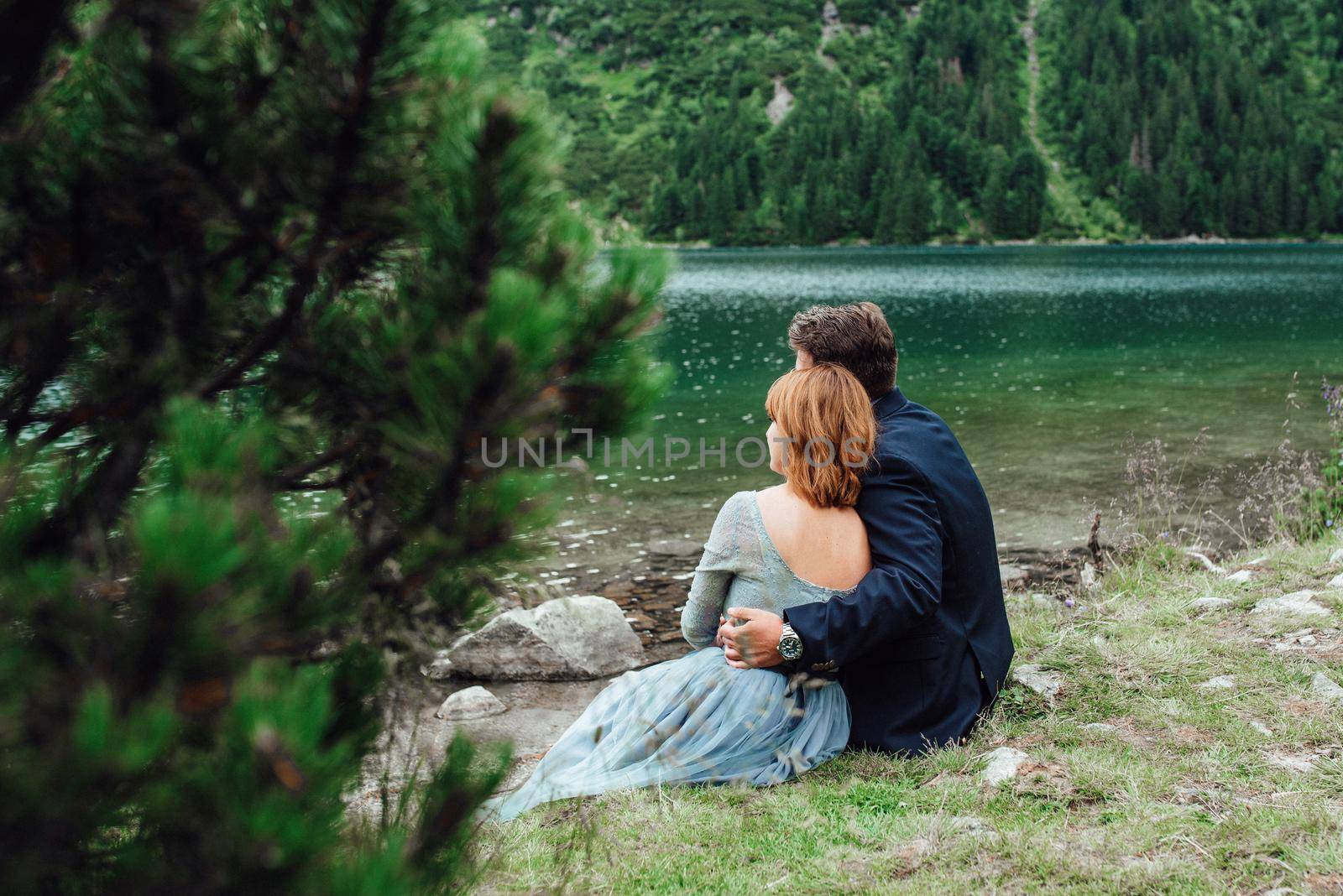 young couple on a walk near the lake surrounded by the Carpathian mountains