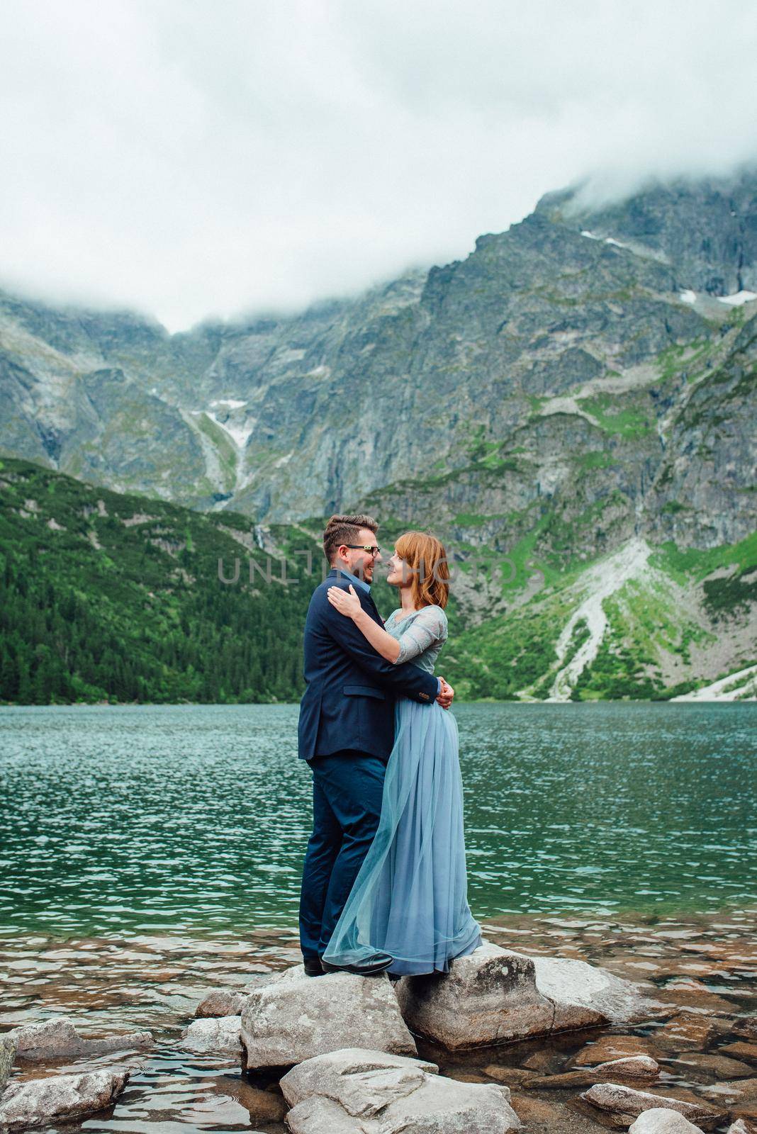 young couple on a walk near the lake surrounded by the Carpathian mountains