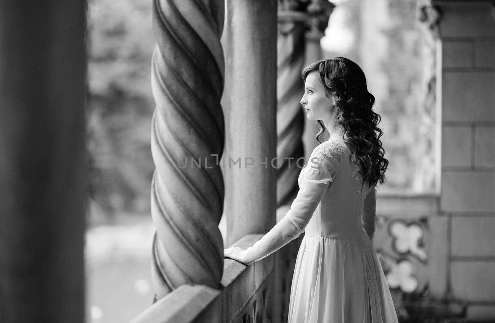 A girl in a light pink dress against the background of a medieval Polish stone castle