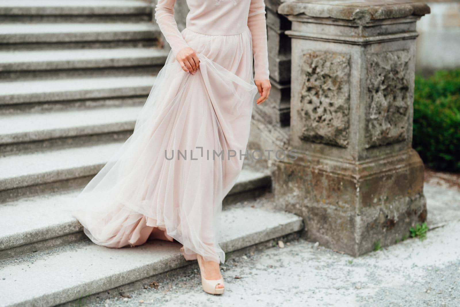 A girl in a light pink dress against the background of a medieval Polish stone castle