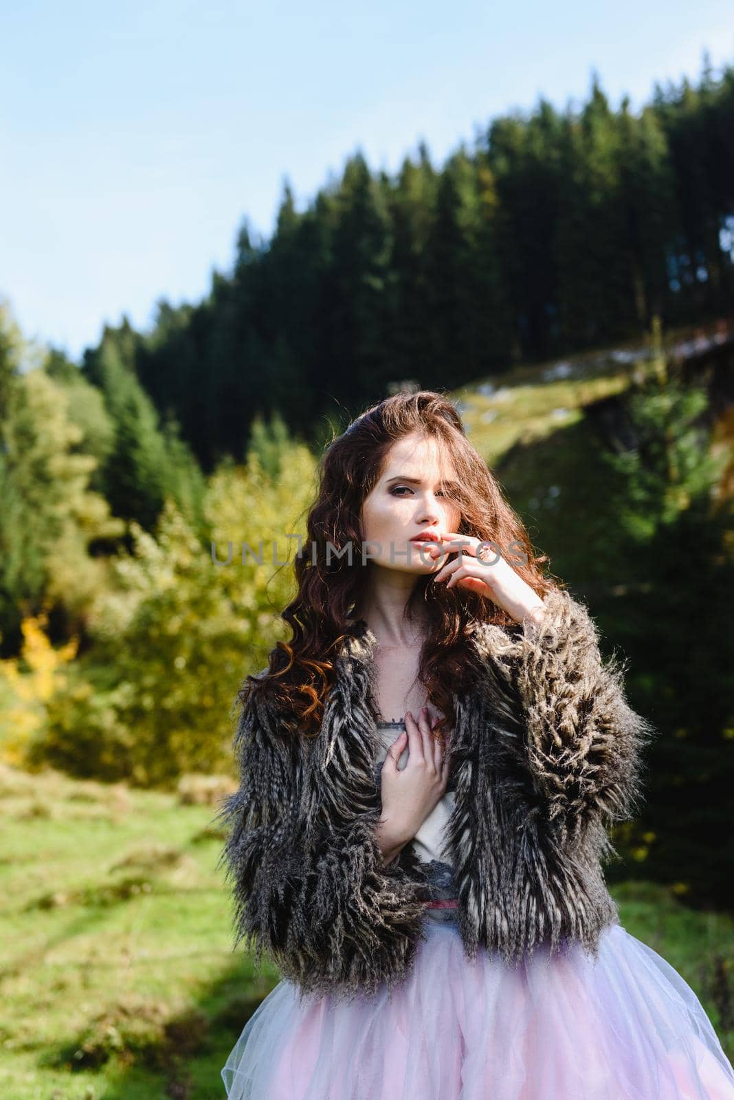 the bride walks under a bridge in a fur Cape in the Carpathians