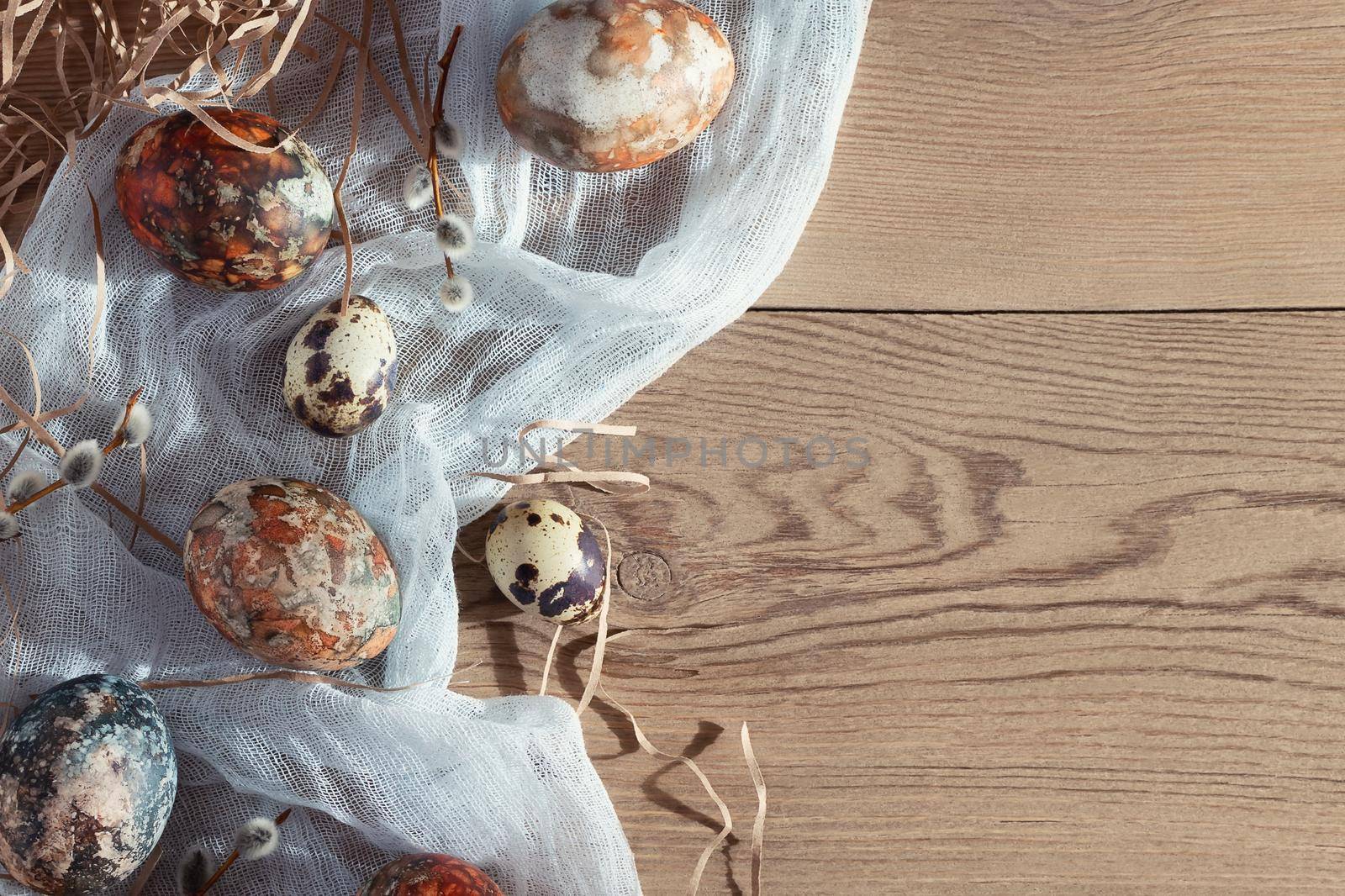 Easter composition - Easter eggs painted with natural dyes on a wooden table, copyspace.