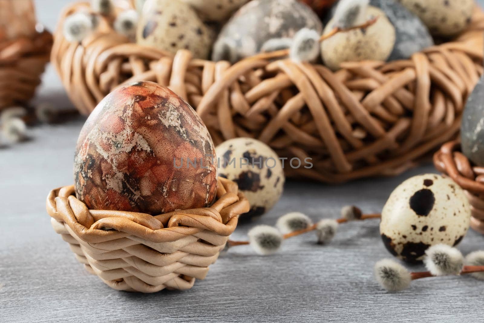 Easter composition - several marble eggs painted with natural dyes in a wicker nest and baskets by galsand