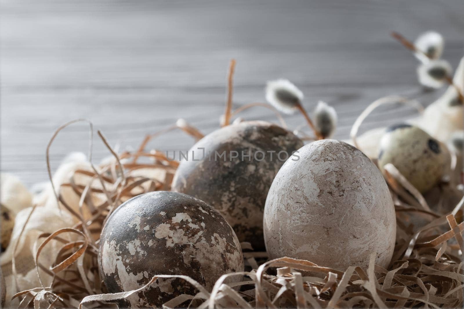 Easter composition - several marble eggs painted with natural dyes in a paper nest on the table, copy space.
