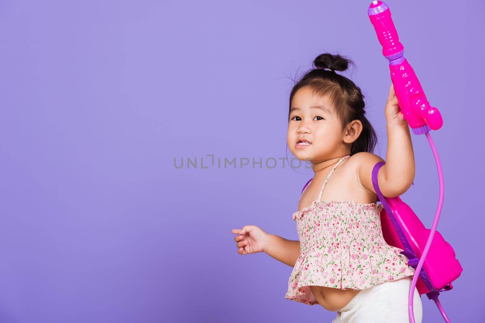 Thai child funny hold toy water pistol and smile by Sorapop