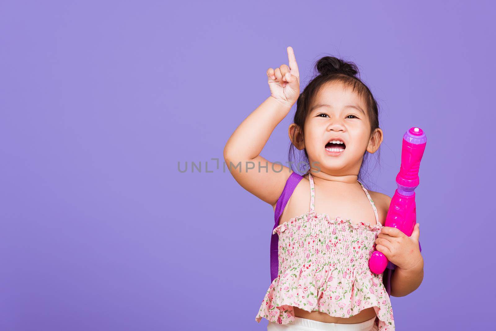 Happy Asian little girl holding plastic water gun by Sorapop