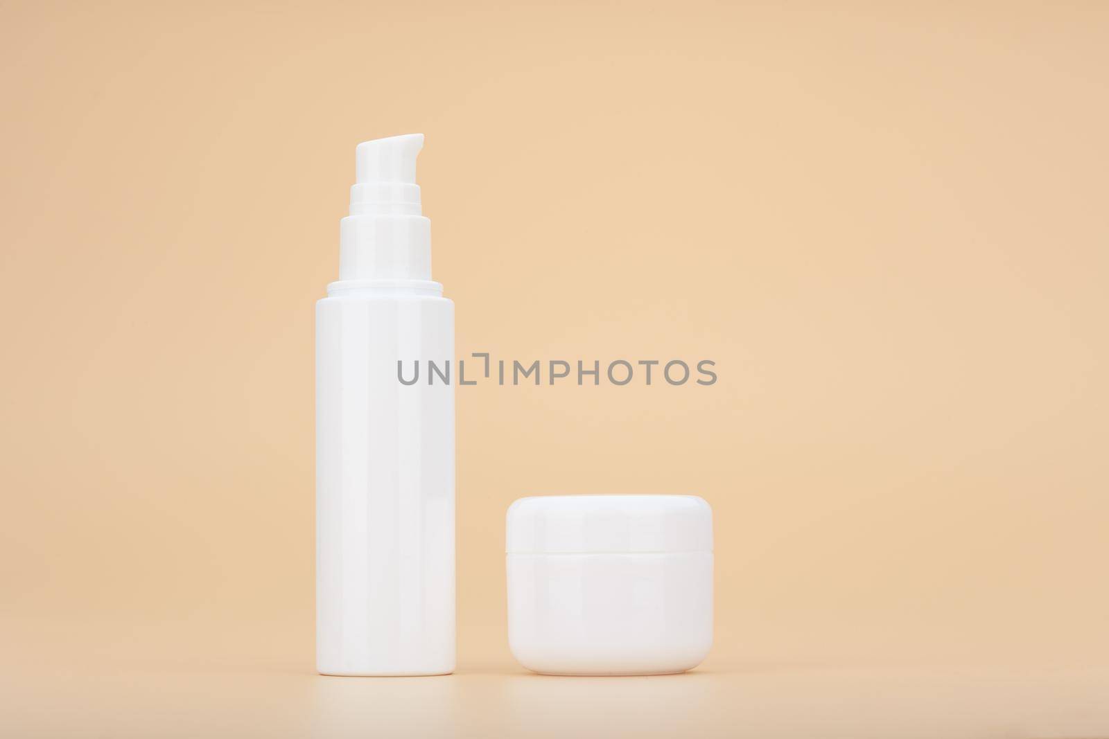 Minimalistic still life with set of face cream and under eye cream against beige background. Concept of beauty products for daily skin care. High quality photo