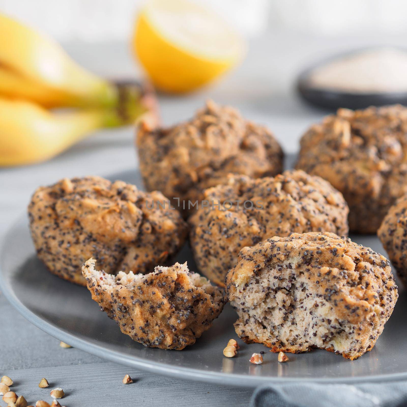Close-up view of healthy gluten-free homemmade banana muffins with buckwheat flour. Vegan muffins with poppy seeds on gray plate over gray wooden table
