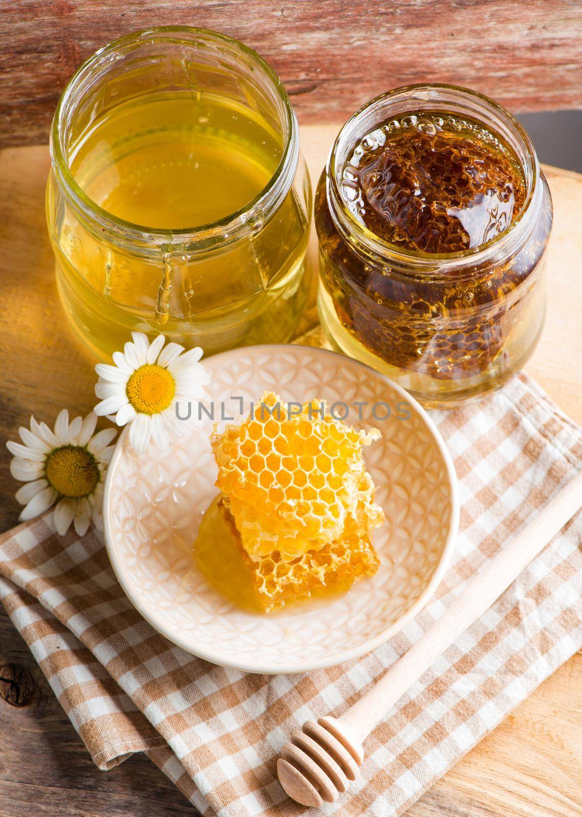 Close up honeycomb with honey in glass jar by aprilphoto