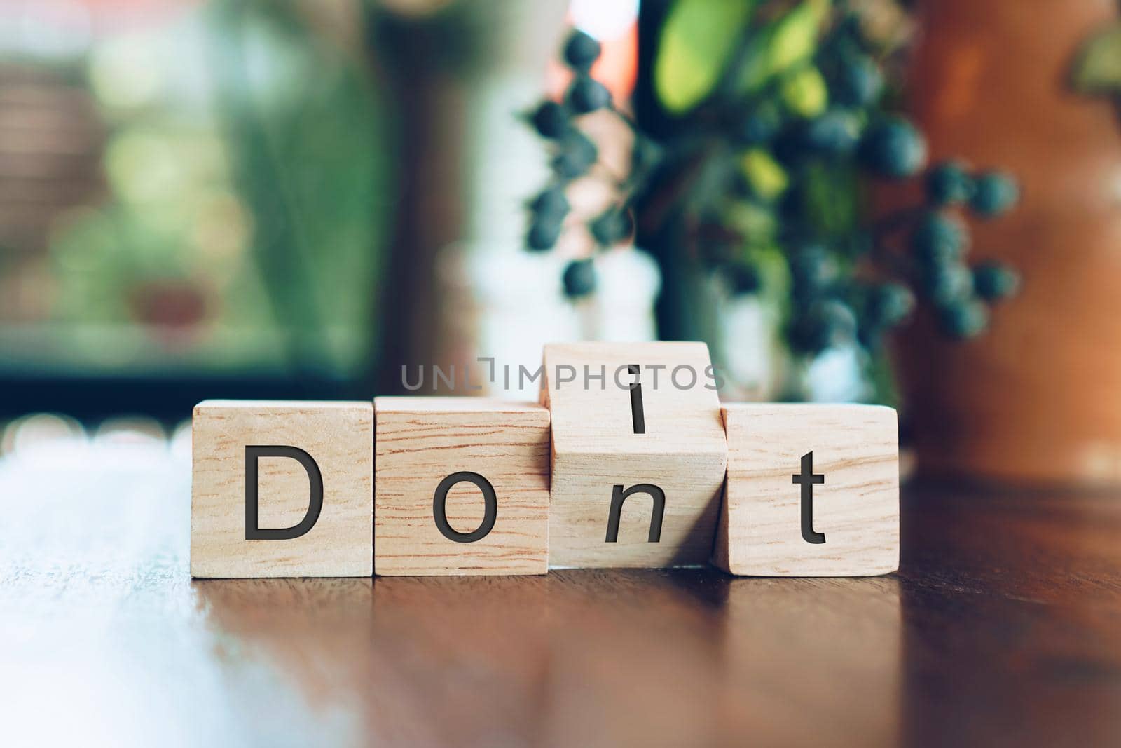 Do it or don't on wooden cube on table. Key to success concept background.