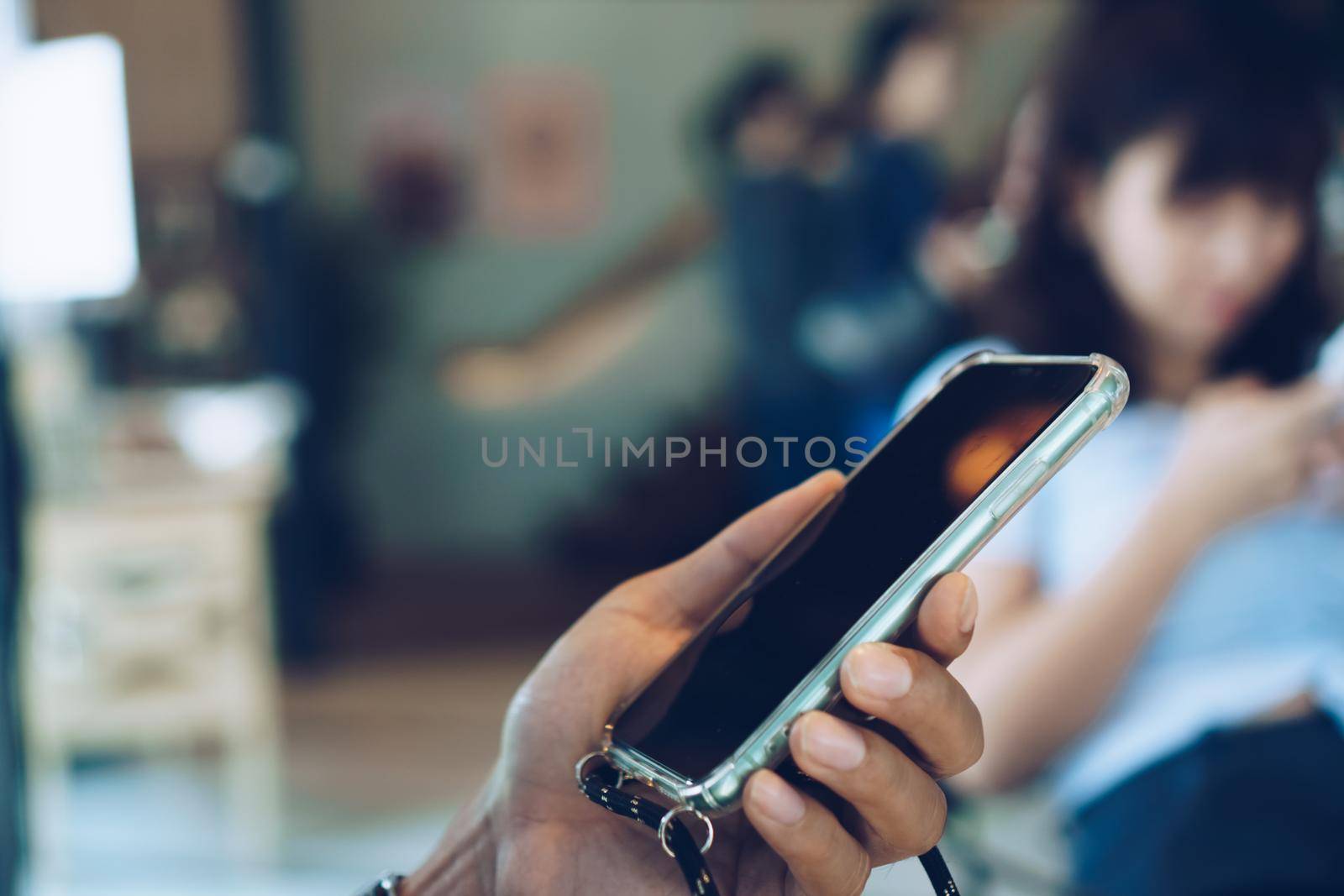 People hand using smartphone to do work business, social network, communication in public cafe work space area.