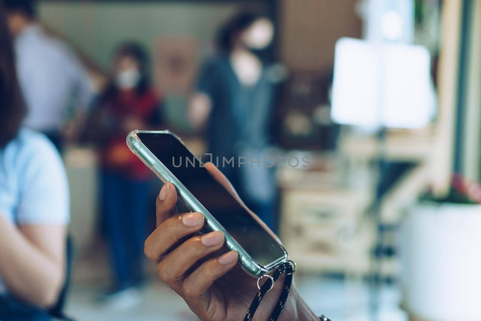 People hand using smartphone to do work business, social network, communication in public cafe work space area.