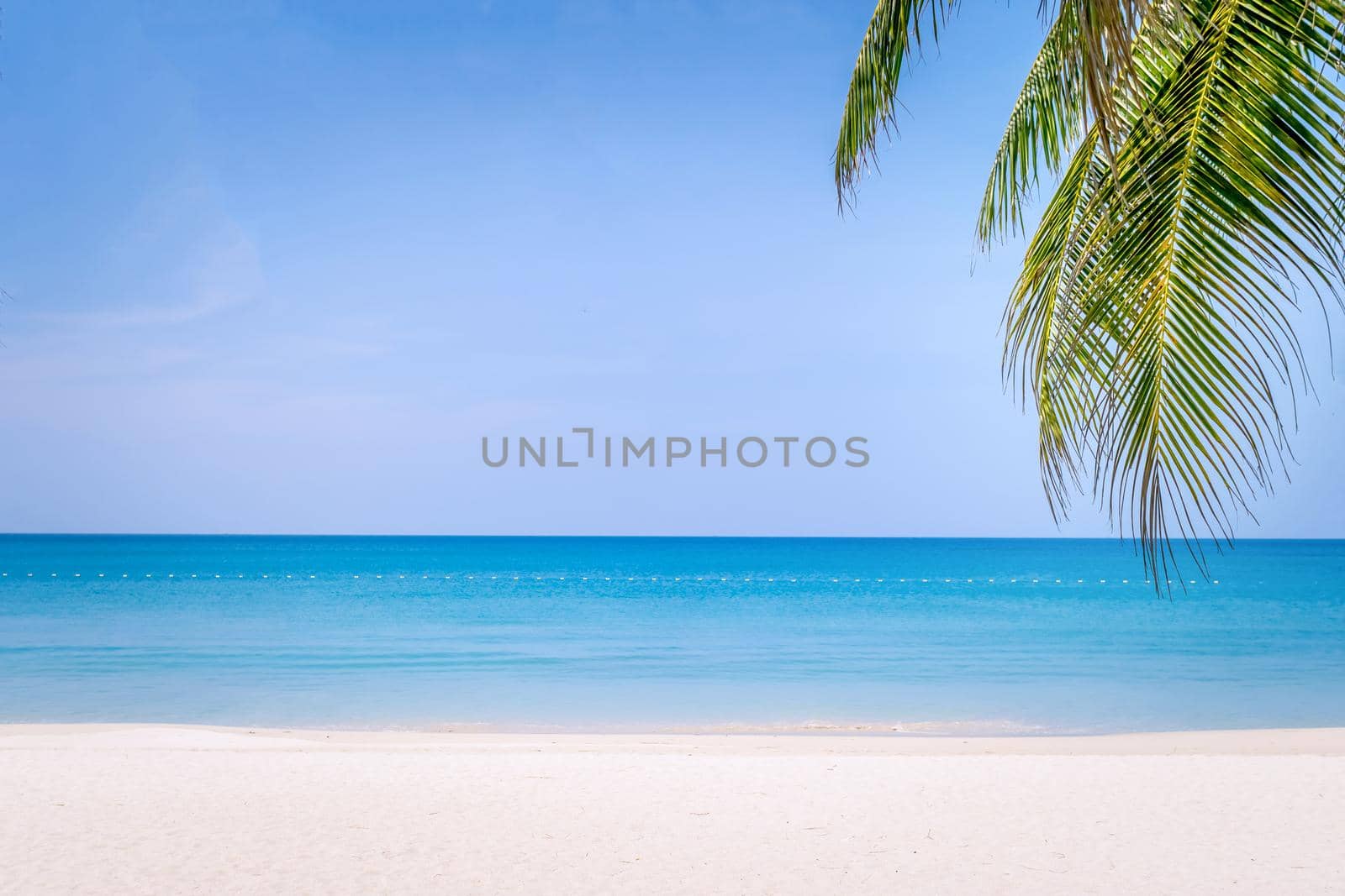 Tropical nature clean beach and white sand in summer season with sun light blue sky background.