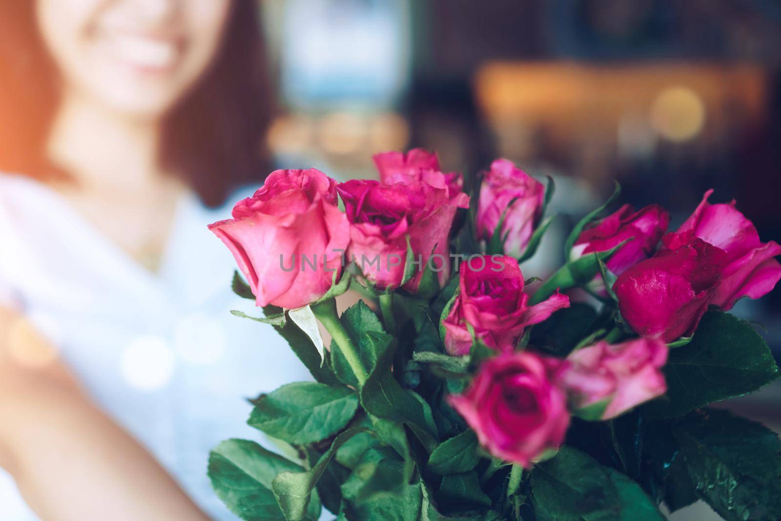 Woman happy hold pink roses recieve from someone in love on Valentine's day.   