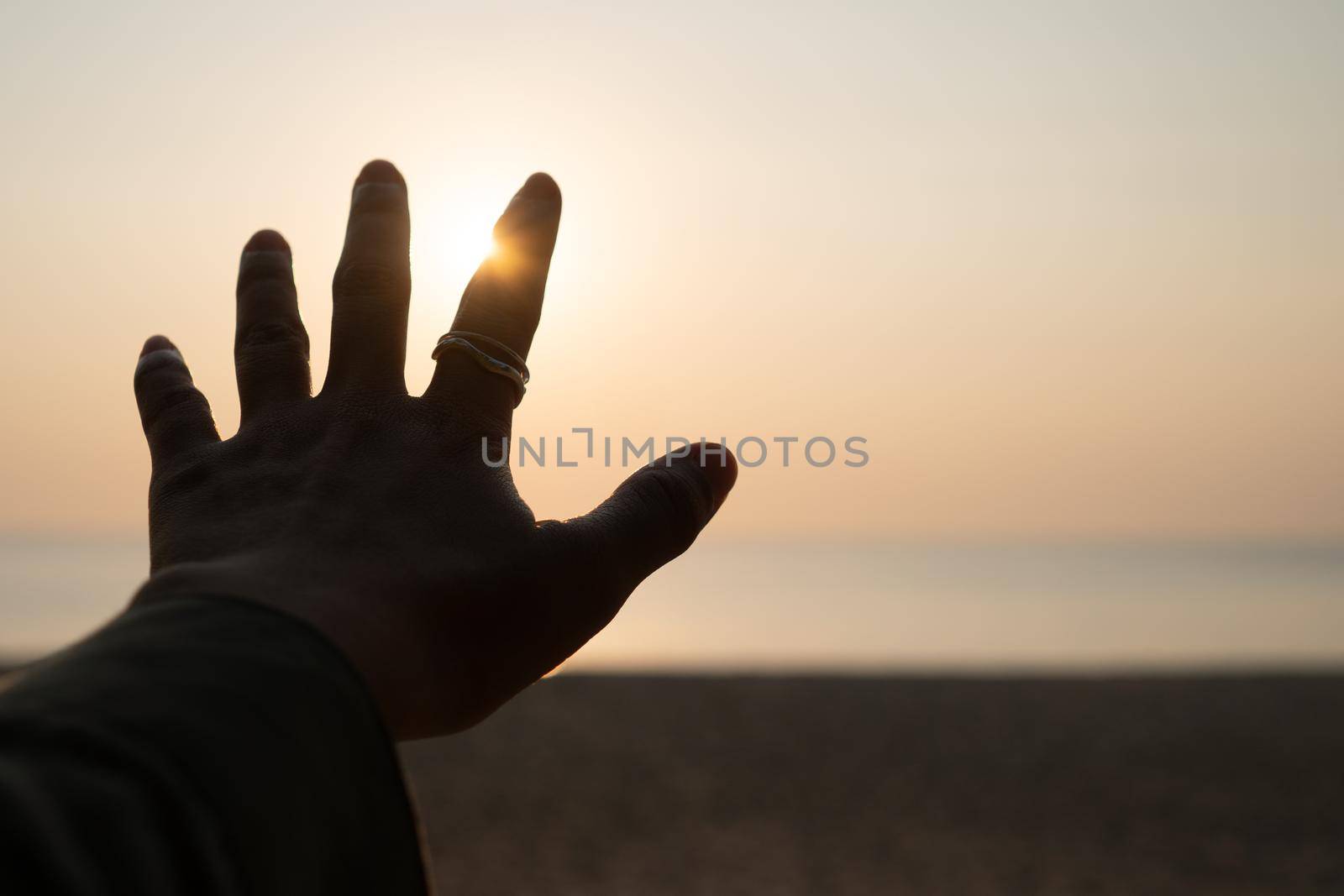 Hand reach out to sunset sky beach sand nature background. Relax and rest in vacation.. by Suwant