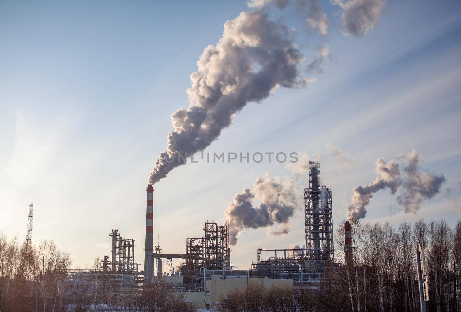 Petrochemical industrial factory of heavy industry, power refinery production with smoke pollution. Thick smoke is coming from the factory's chimney