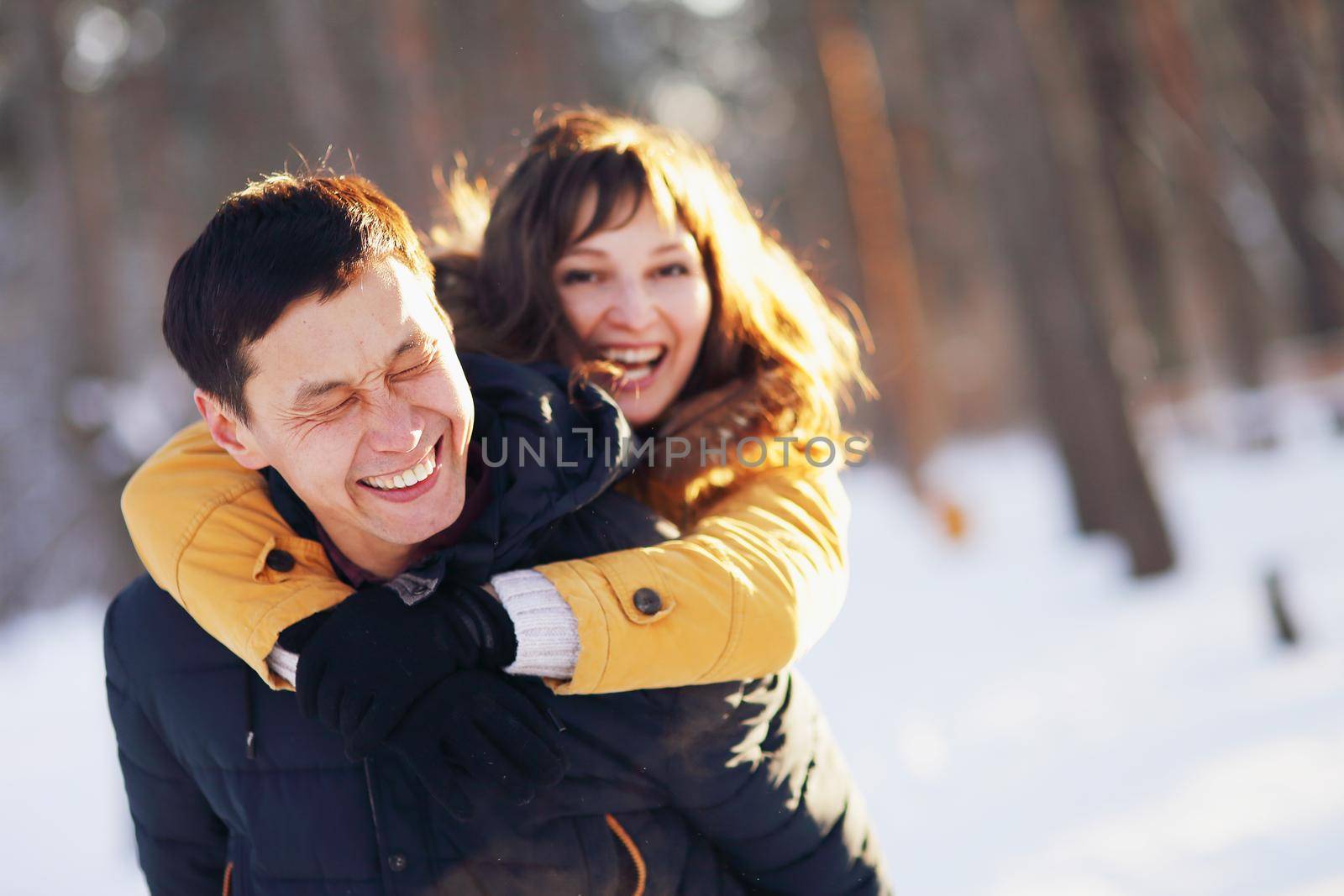 Young couple in love having fun in winter forest.