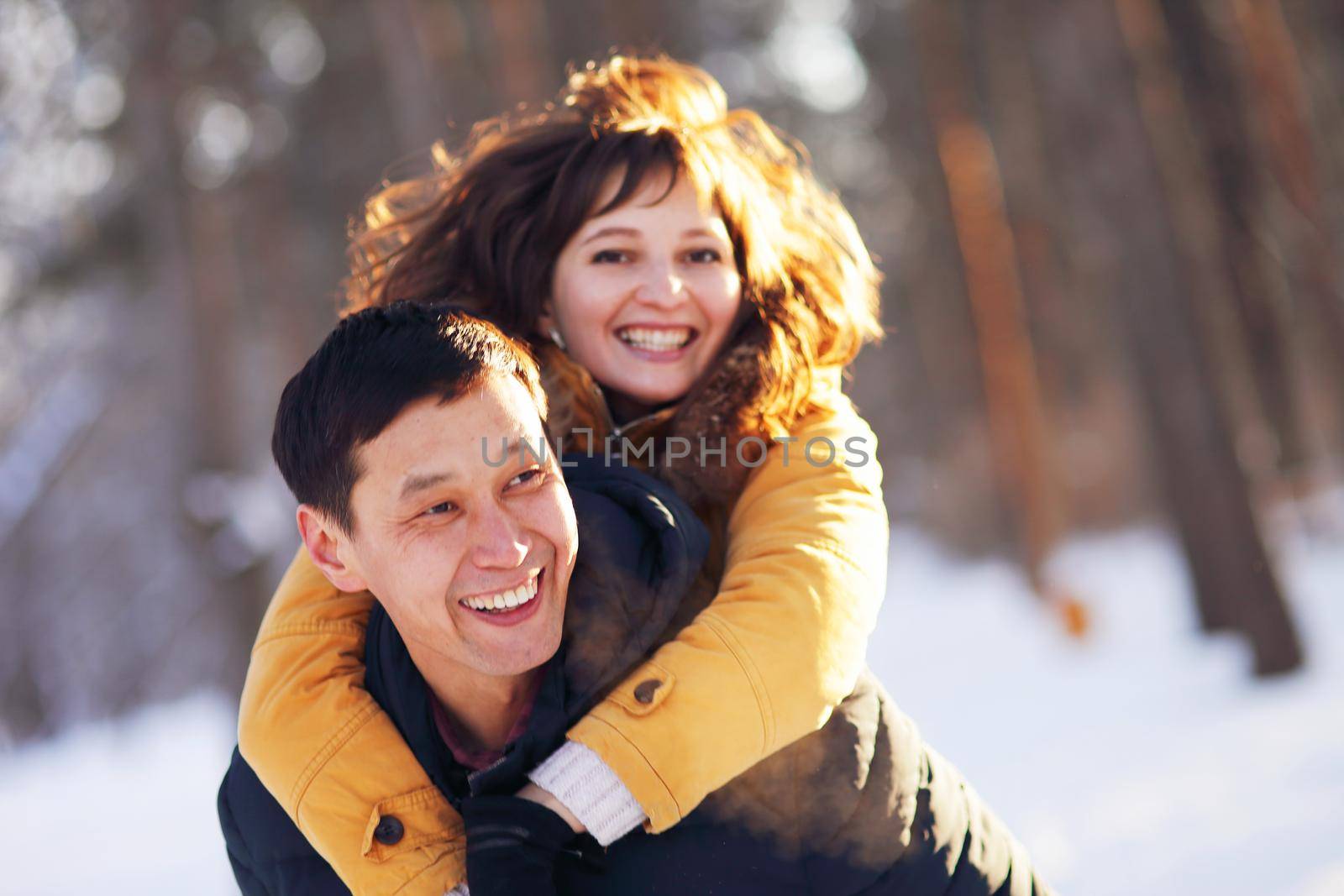 Young couple in love having fun in winter forest by selinsmo