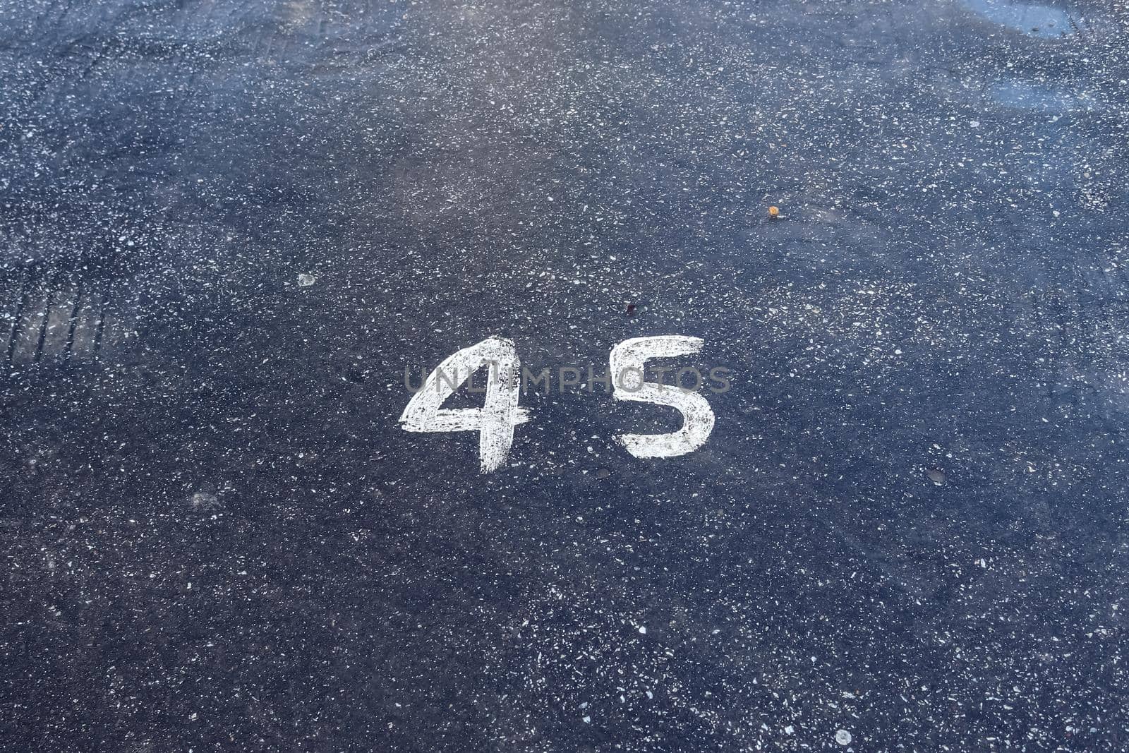 Numbers painted on concrete and asphalt textured surfaces