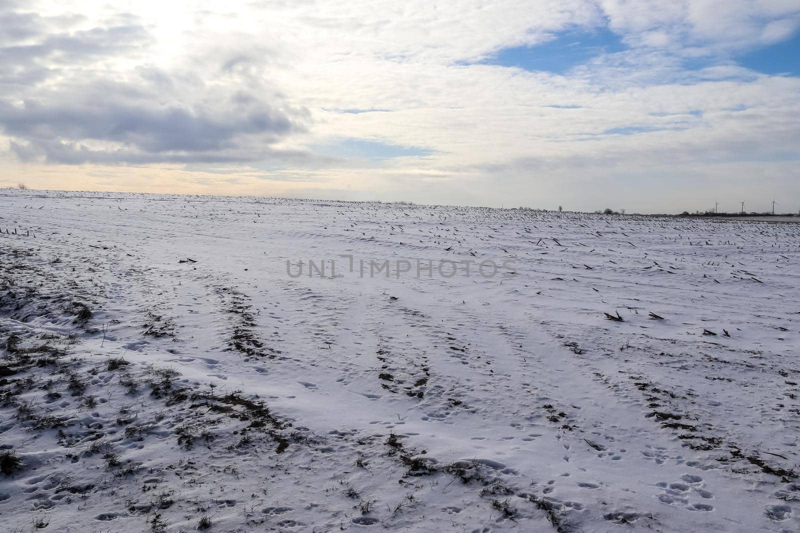 Beautiful clouds in the sky looking over a snow covered agricultural field