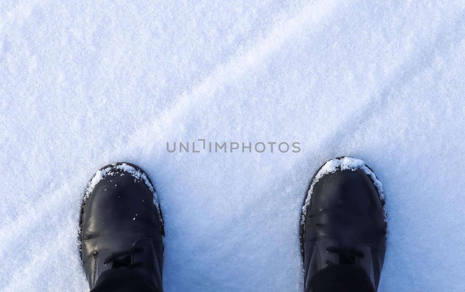 High angle view at black boots standing in fresh snow. by MP_foto71