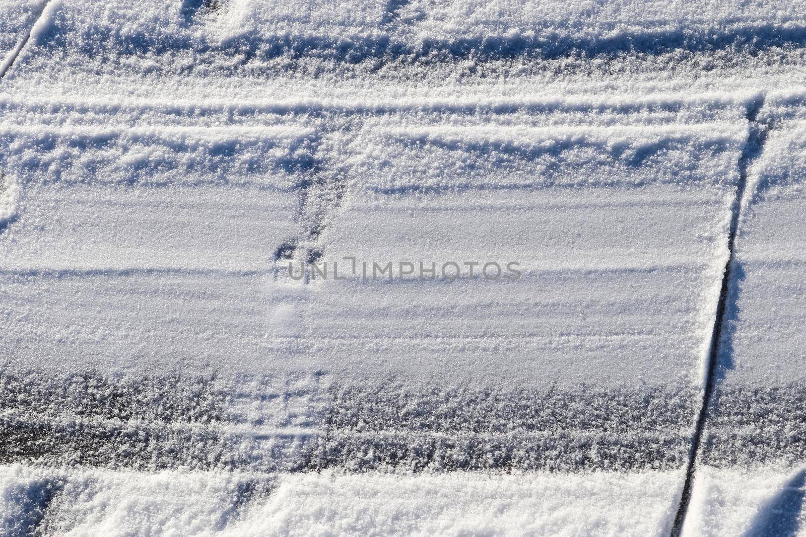 Tire Tracks on snow covered streets in a close up view. by MP_foto71