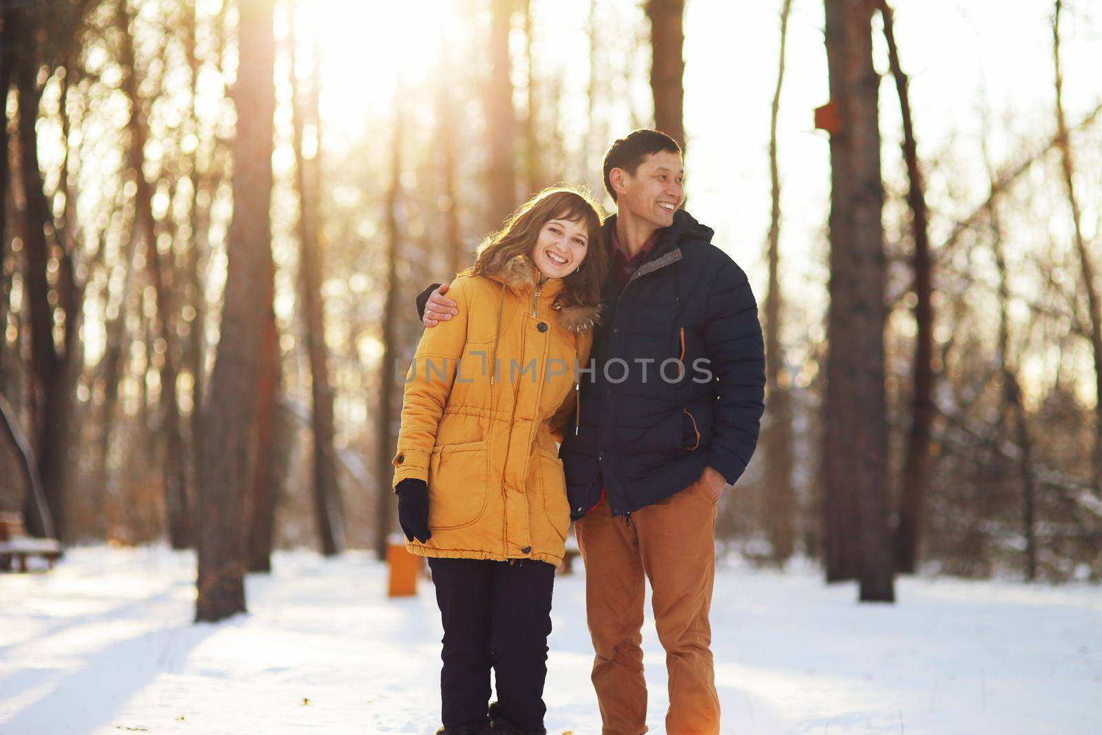 Warm winter portrait of a couple of different race in the forest by selinsmo