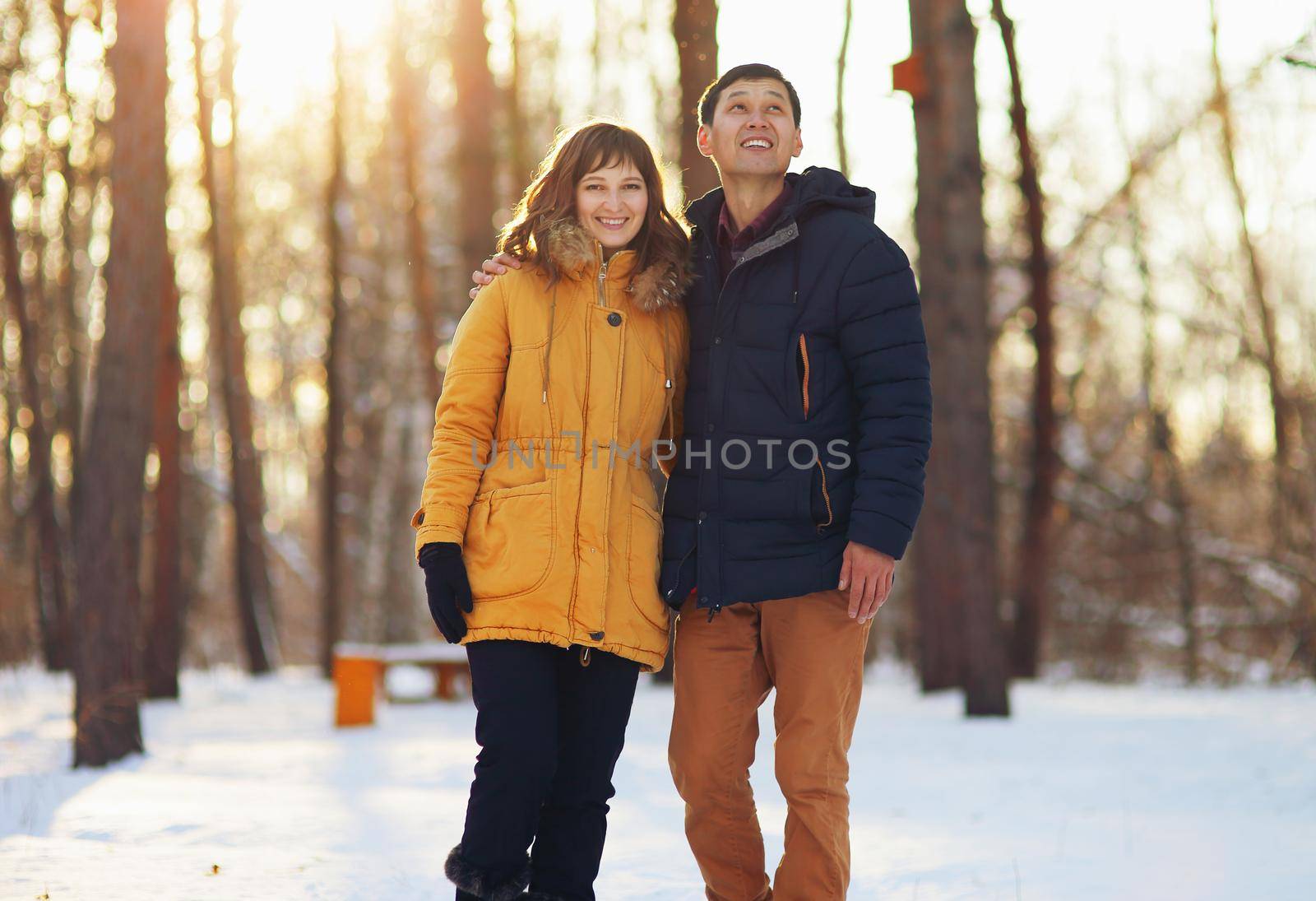 Warm winter portrait of a couple of different race in the forest.