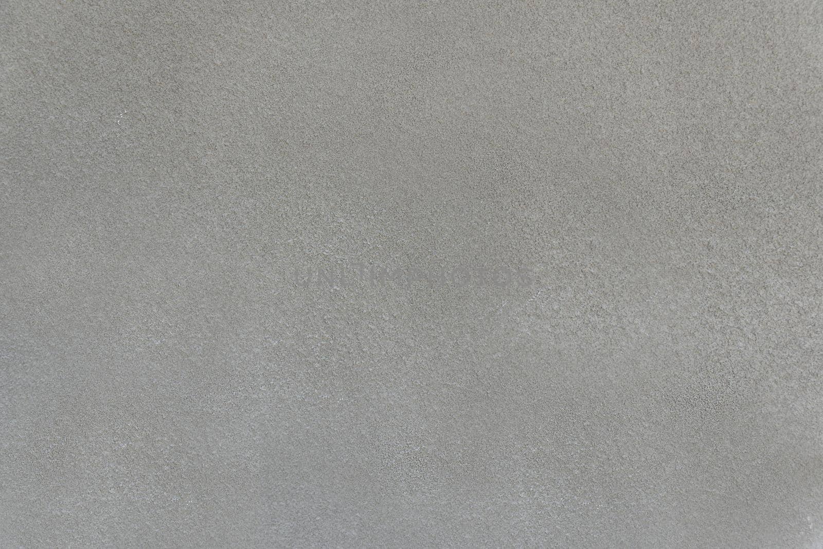 Rough and rough concrete surface of a gray wall close-up.Texture or background